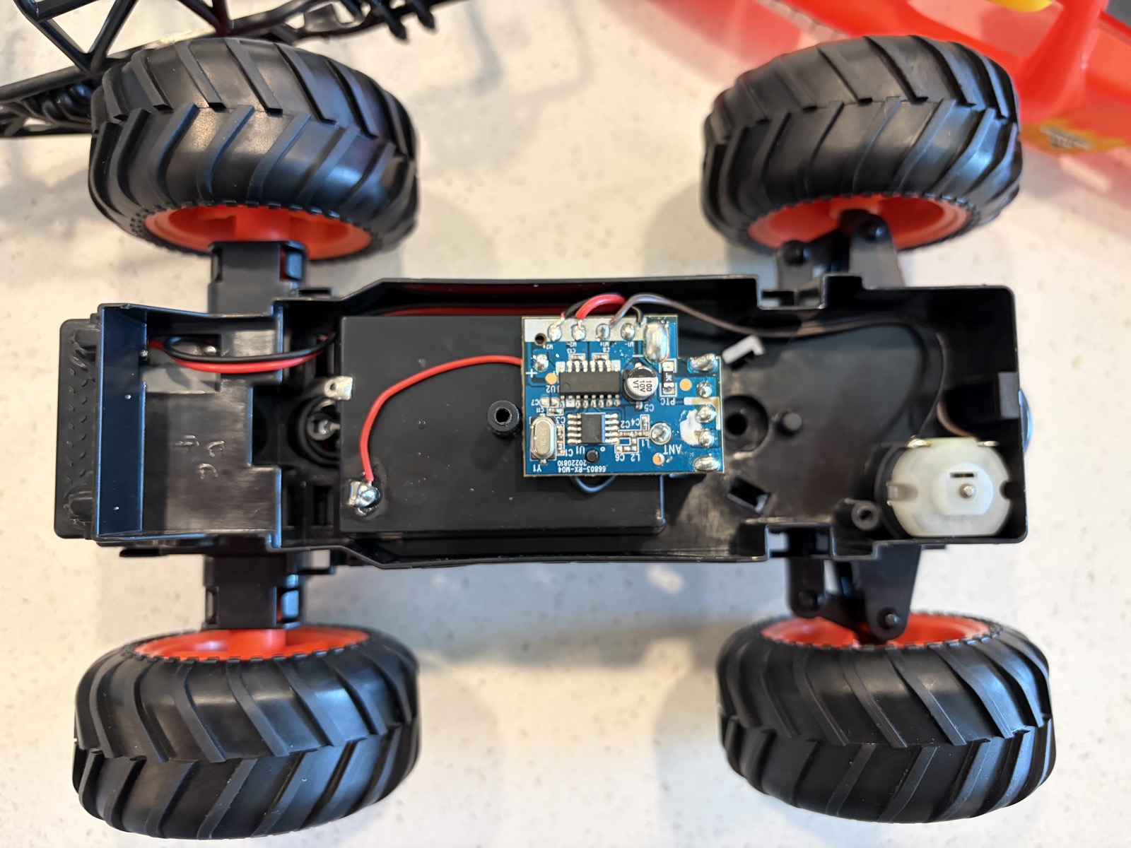 the monster truck after disassembly — chassis, motors, battery hookups, and PCB exposed